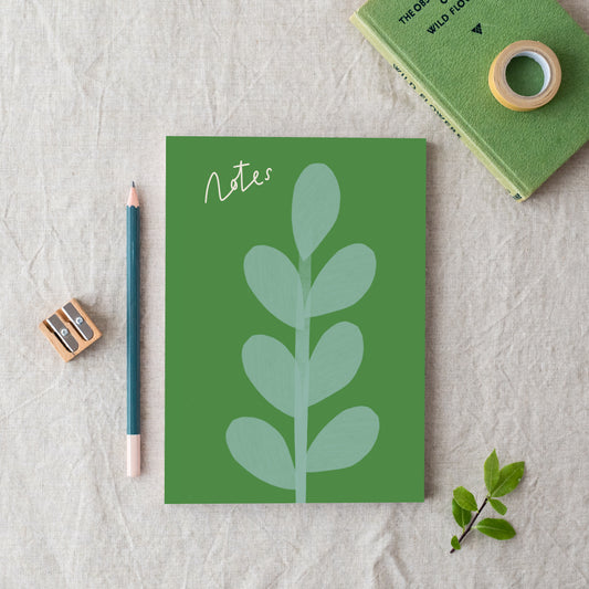 An A5 notebook with a green cover featuring a branch pattern, titled 'Notes', Made in Britain from bleed proof, eco-friendly, recycled paper with 100gsm inner pages.