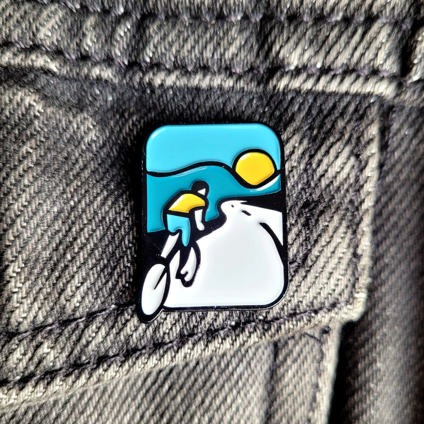 Pin with a design of a biker on a denim jacket