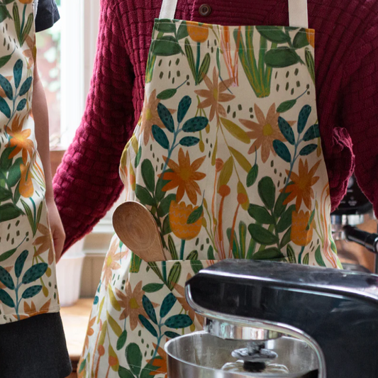 An adult with a floral design cotton apron. made in britain.