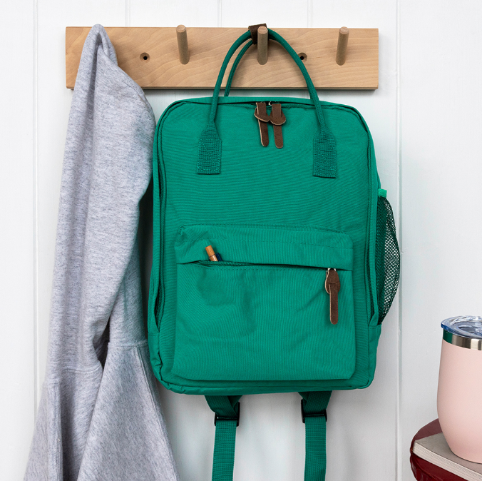 compact green backpack on a hanging peg