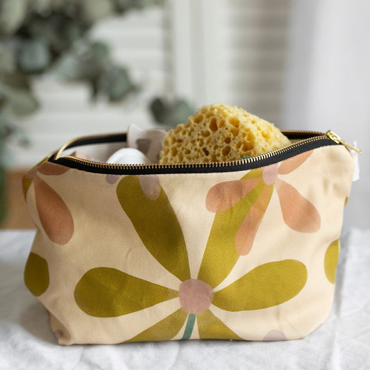 A beige floral wash bag with a green daisy pattern, Printed on sustainable cotton, with a high quality YKK brass zip and natural panama cotton lining.