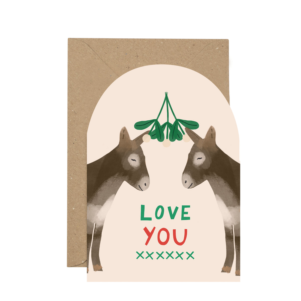 A greeting card with a kraft envelope behind it, featuring an illustration of two donkeys around a hanging green mistletoe, with the words “LOVE YOU” in green and red on a cream background.