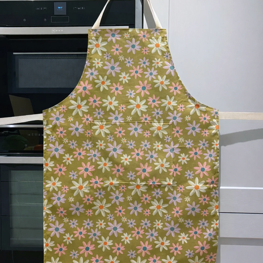 Floral apron hanging in a kitchen with an oven in the background