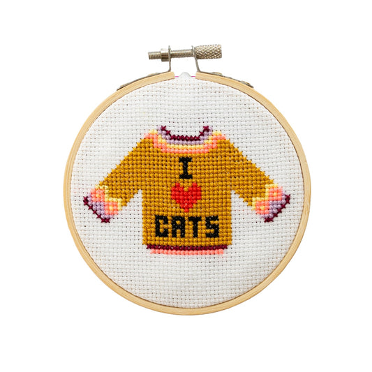 Cross-stitched design of a sweater with 'I ❤️ Cats' text in a wooden hoop.
