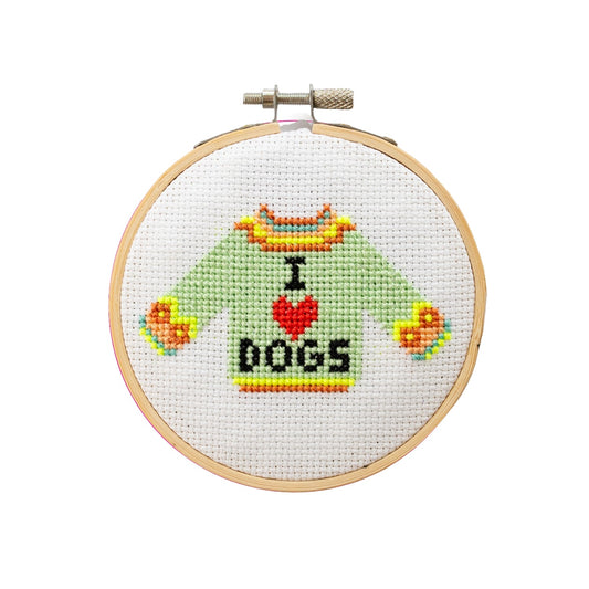Cross-stitched design of a sweater with 'I ❤️ DOGS' text in a wooden hoop.