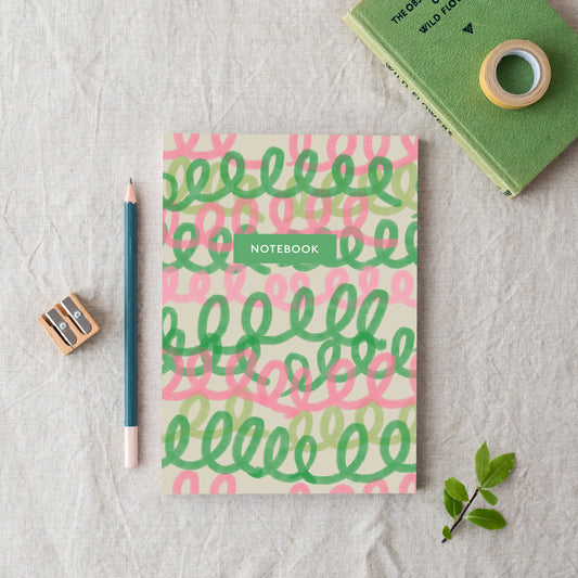 An A5 notebook with a green and pink loop pattern on the cover, made in Britain from bleed proof, eco-friendly, recycled paper with 100gsm inner pages.
