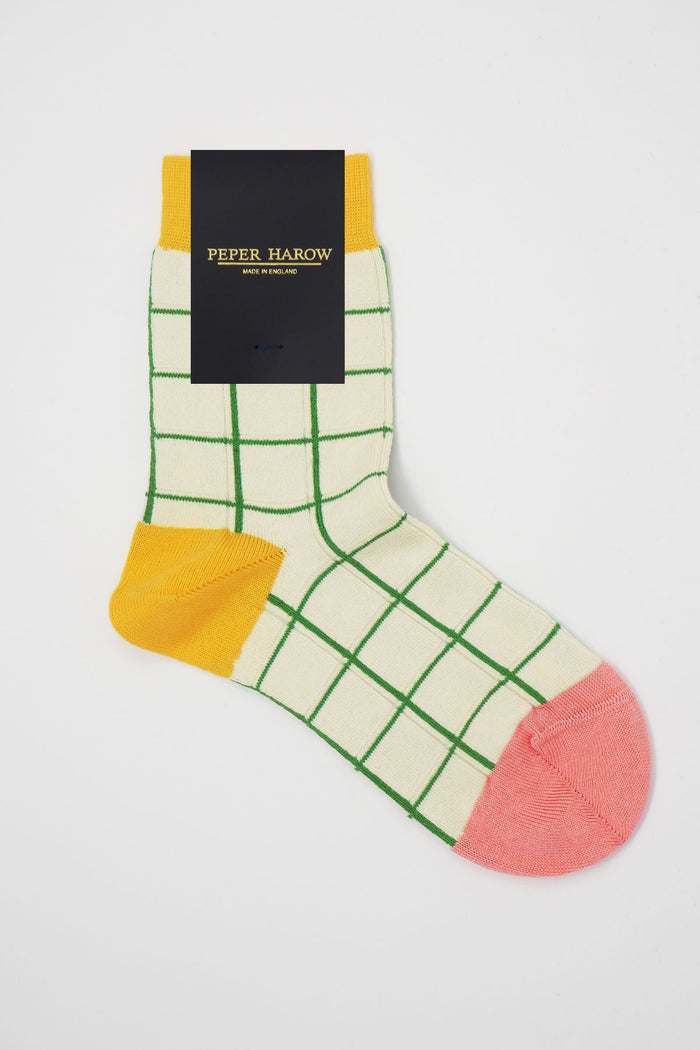 Colorful checkered sock with a Peper Harow label on a light gray background