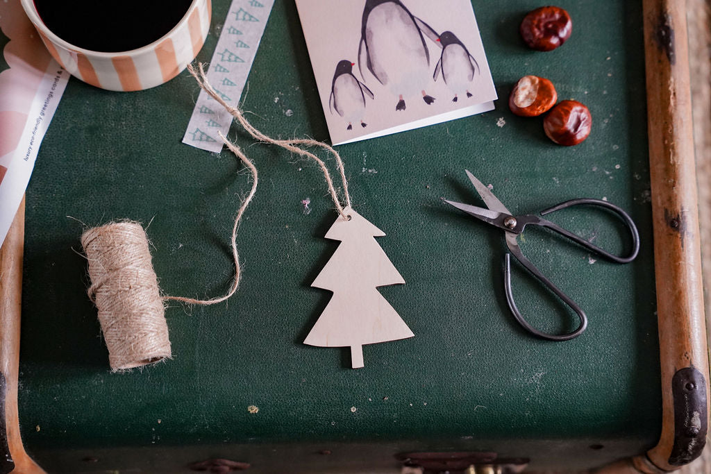 a plywood christmas tree decoration on a chest, surrounded by lots of craft supplies