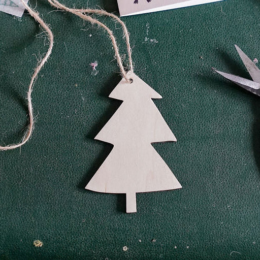 a tree shaped wooden decoration on a green background with gardeners twine