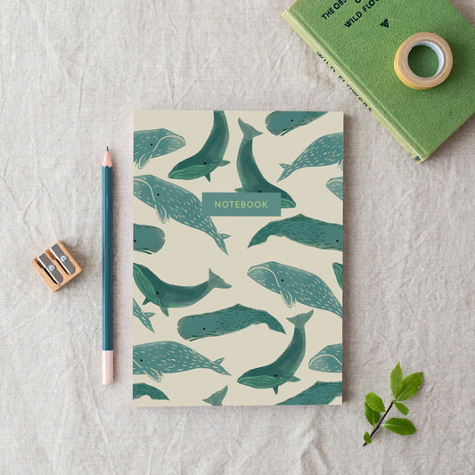 A beige A5 notebook with a whale pattern made in Britain from bleed proof, eco-friendly, recycled paper with 100gsm inner pages.hale pattern,