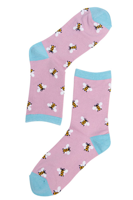 Pink socks with bee pattern and blue accents on a white background