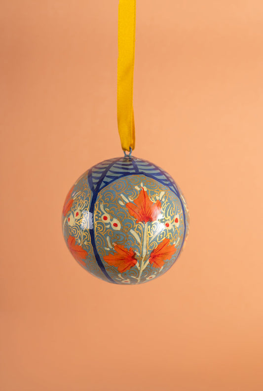 Handmade decorative christmas ornament with floral design on a peach background