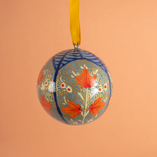 Handmade decorative christmas ornament with floral design on a peach background
