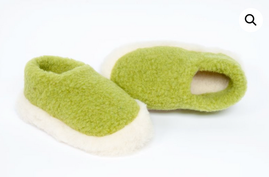 Pair of green slippers with white soles on a white background