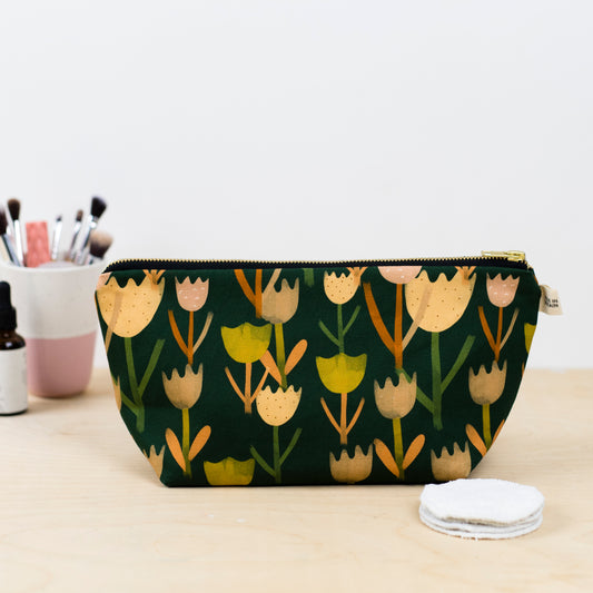 A green wash bag with a multicolor tulip pattern, Printed on sustainable cotton, with a high quality YKK brass zip and natural panama cotton lining.