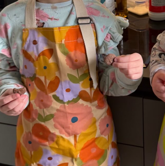 Two children in colorful aprons standing in a kitchen with text overlay.