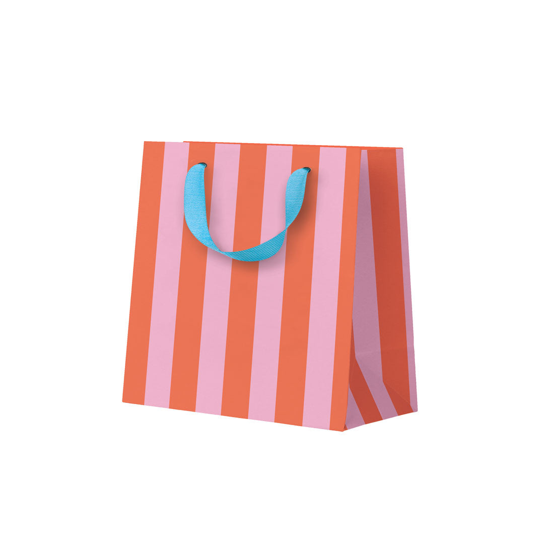 Striped paper bag with pink and orange stripes and blue handles on a white background