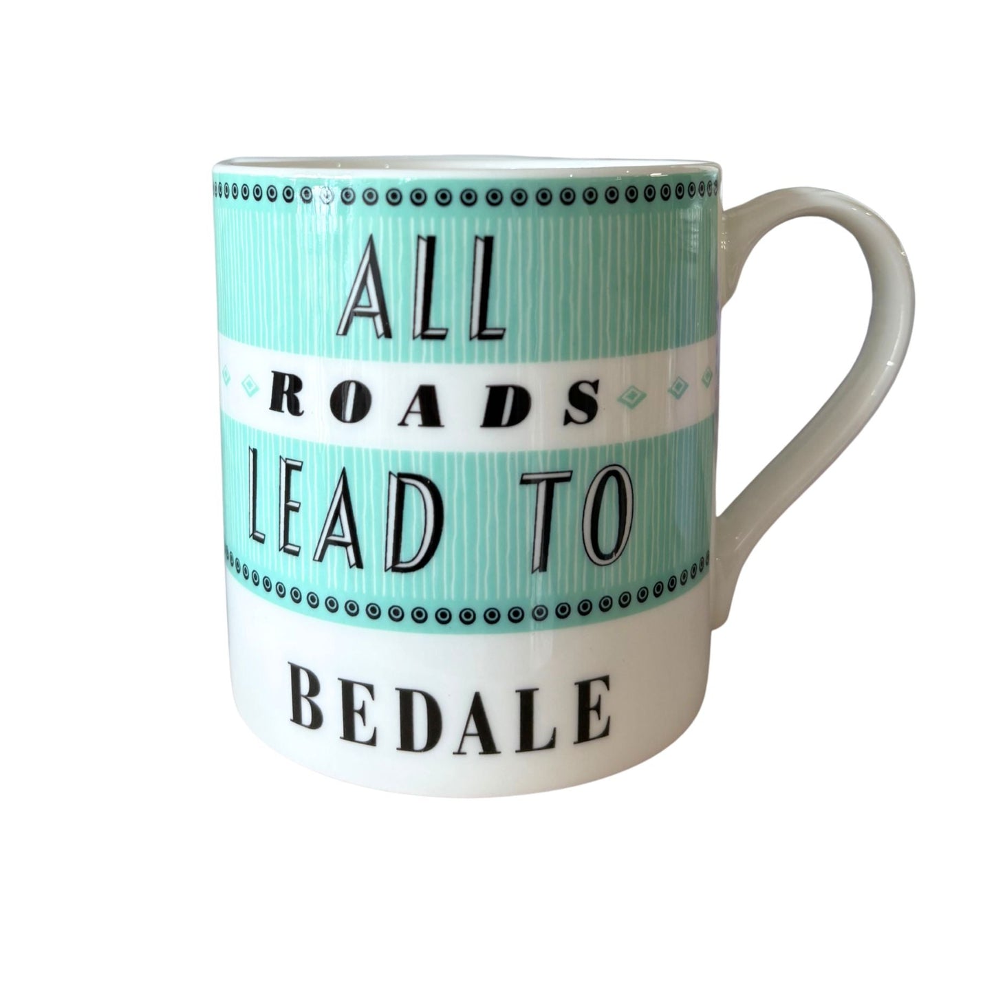 A white ceramic mug with a mint green and white printed design that reads 'ALL ROADS LEAD TO BEDALE' in black text.