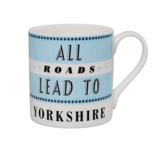 A white ceramic mug with a light blue and white striped design, featuring the text 'ALL ROADS LEAD TO YORKSHIRE' in black lettering.