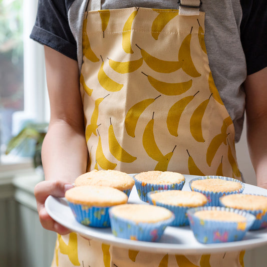 Child's  banana-patterned apron with adjustable neck strap. 100% cotton 