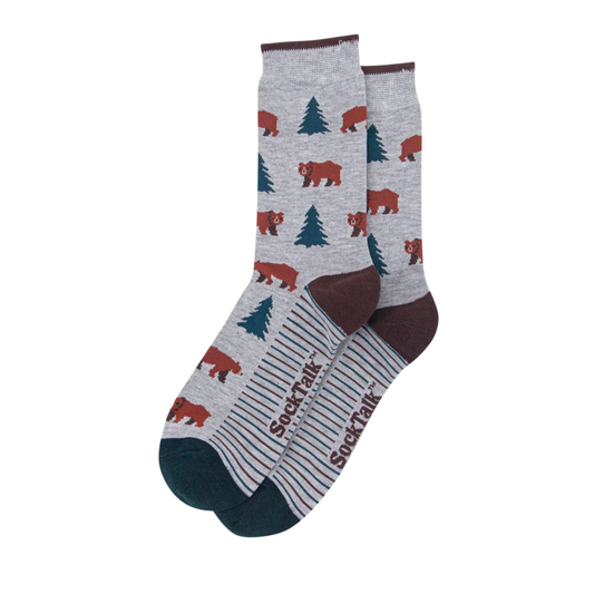 A pair of crew socks with a heather gray background featuring a pattern of brown bears and dark green pine trees. The toes and heels are dark brown, and the soles are dark teal.