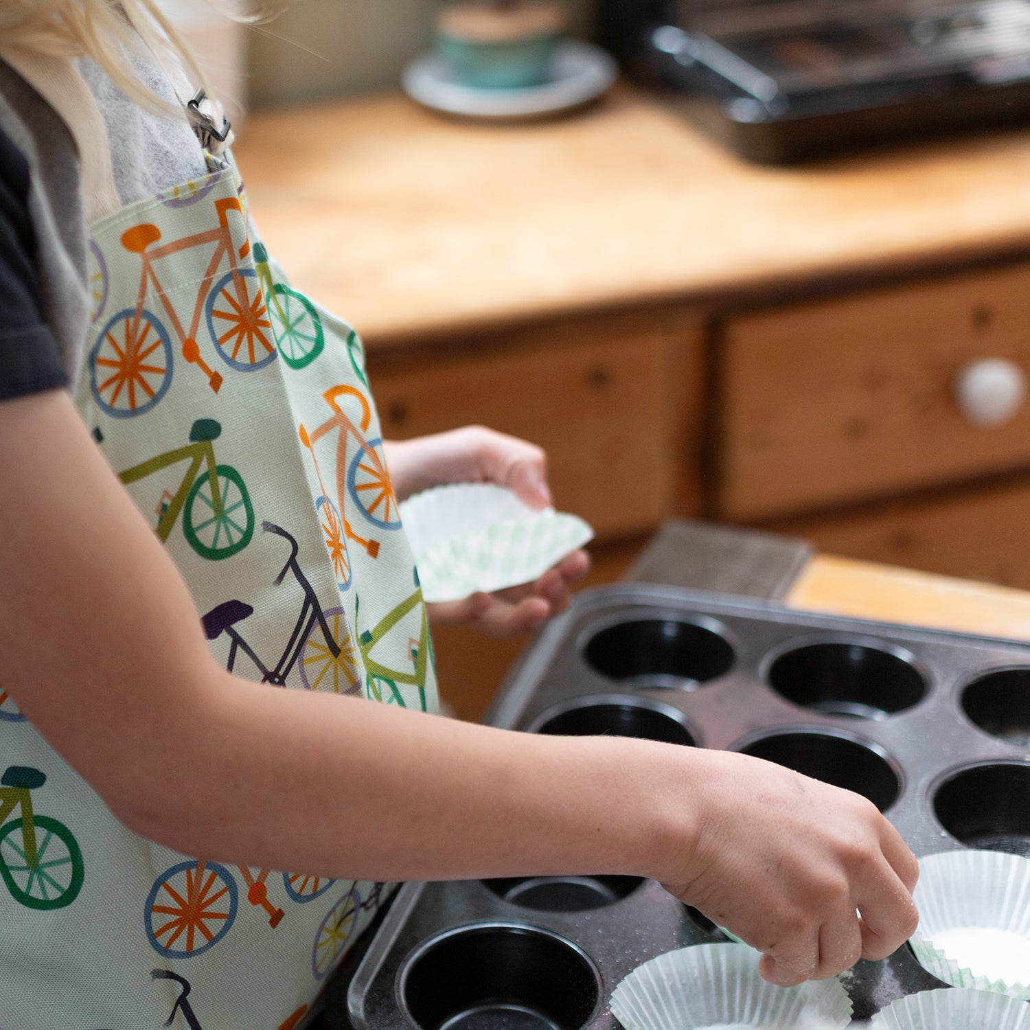 Children apron with colourful bicycle design. Adjustable neck strap.