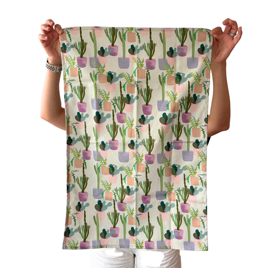 Person holding a towel with cactus pattern against a white background