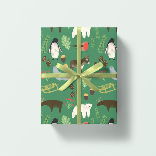 A rectangular gift box wrapped in green wrapping paper with a winter animal and nature print, tied with a light green ribbon, shown on a light gray background.