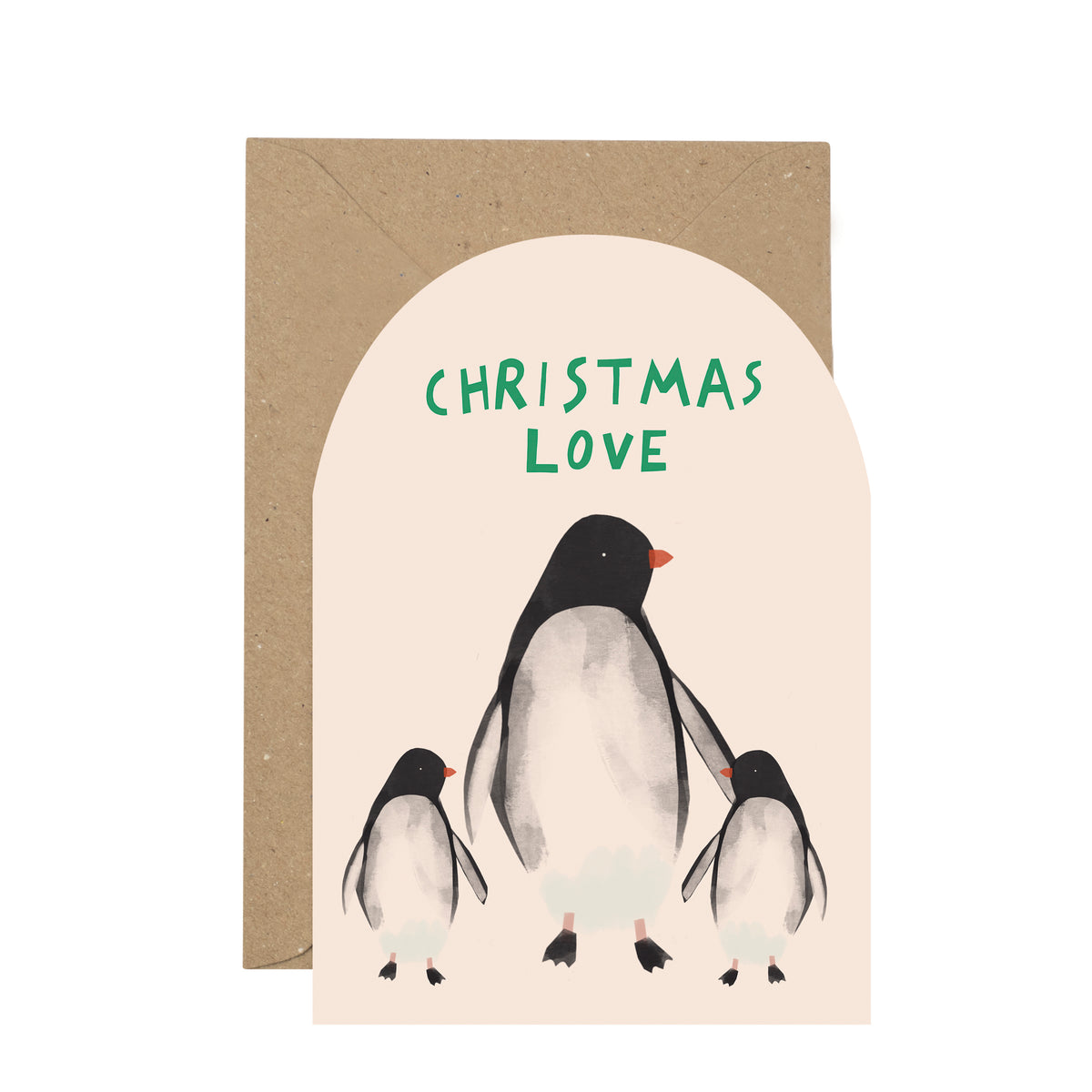 A Christmas greeting card with an arched cream front featuring three penguin illustrations and the words 'CHRISTMAS LOVE' in green, shown with a brown kraft envelope behind it on a white background.