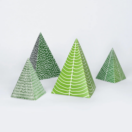 Four green triangular paper trees with patterned designs on a white background