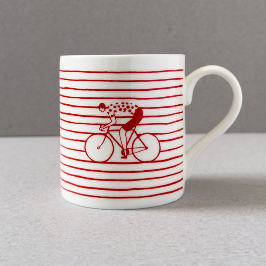 White mug with red stripes and a cyclist design on a gray background
