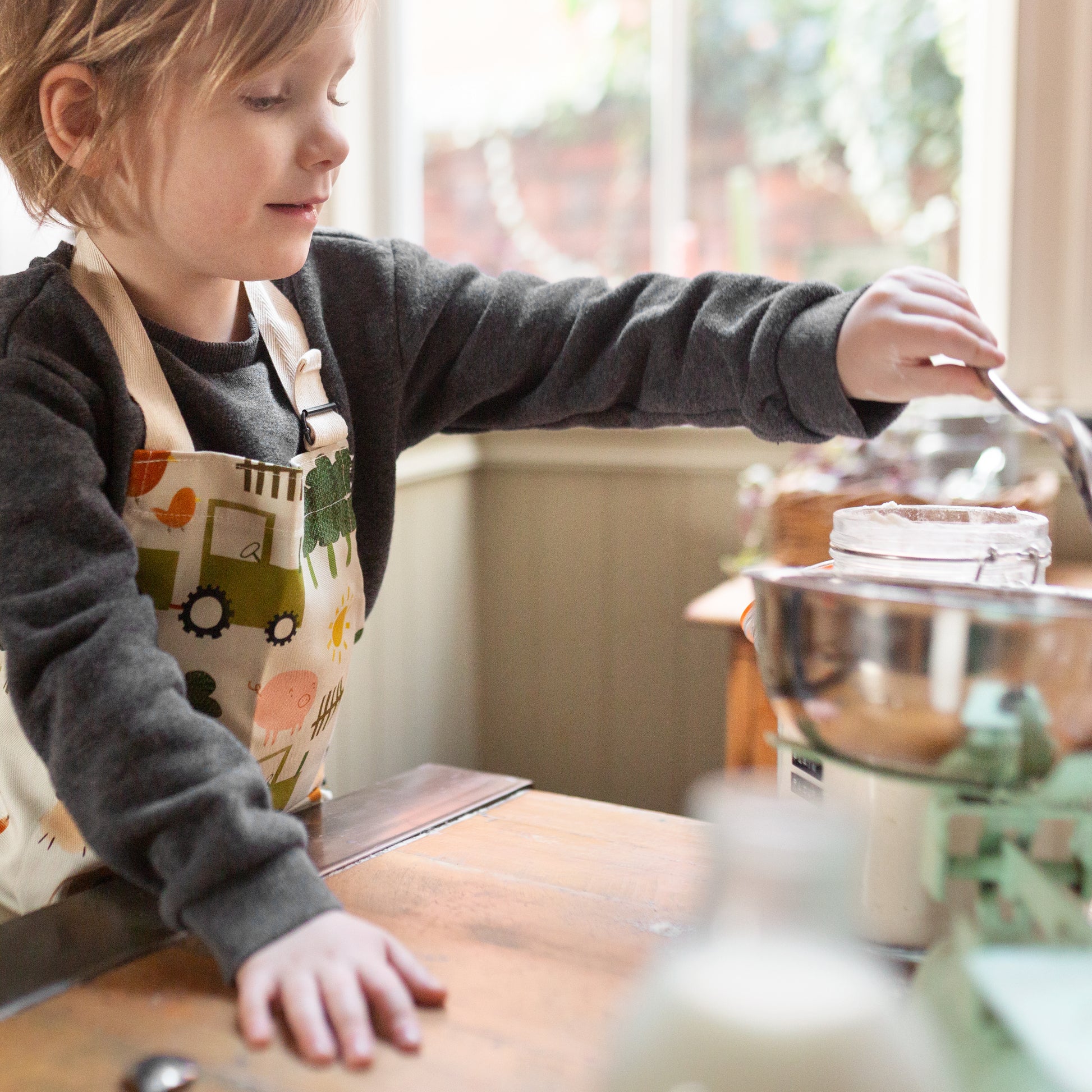 child's apron with farmyard design, adjustable neck strap, 100% cotton. Made in Britain.