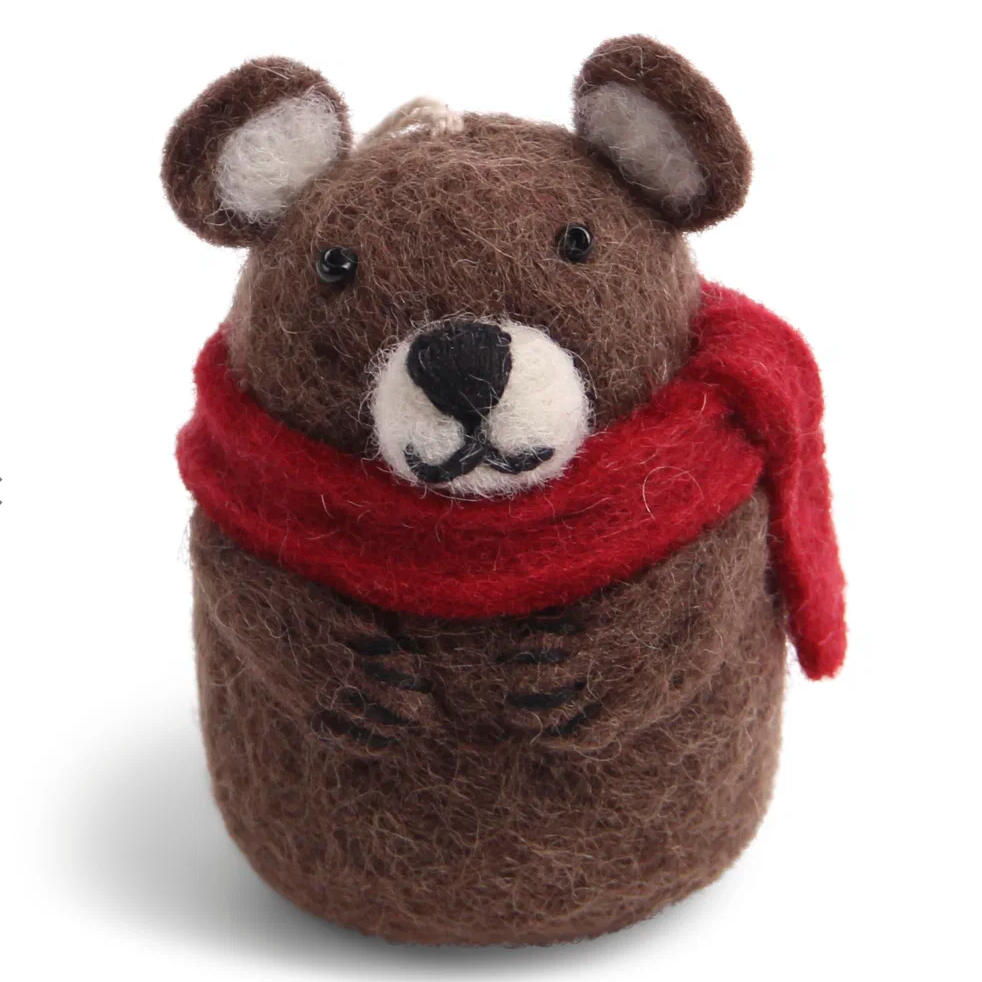 A felted wool teddy bear ornament or plush toy in medium brown with a red scarf, white muzzle, and black embroidered facial details, photographed on a clean white background.