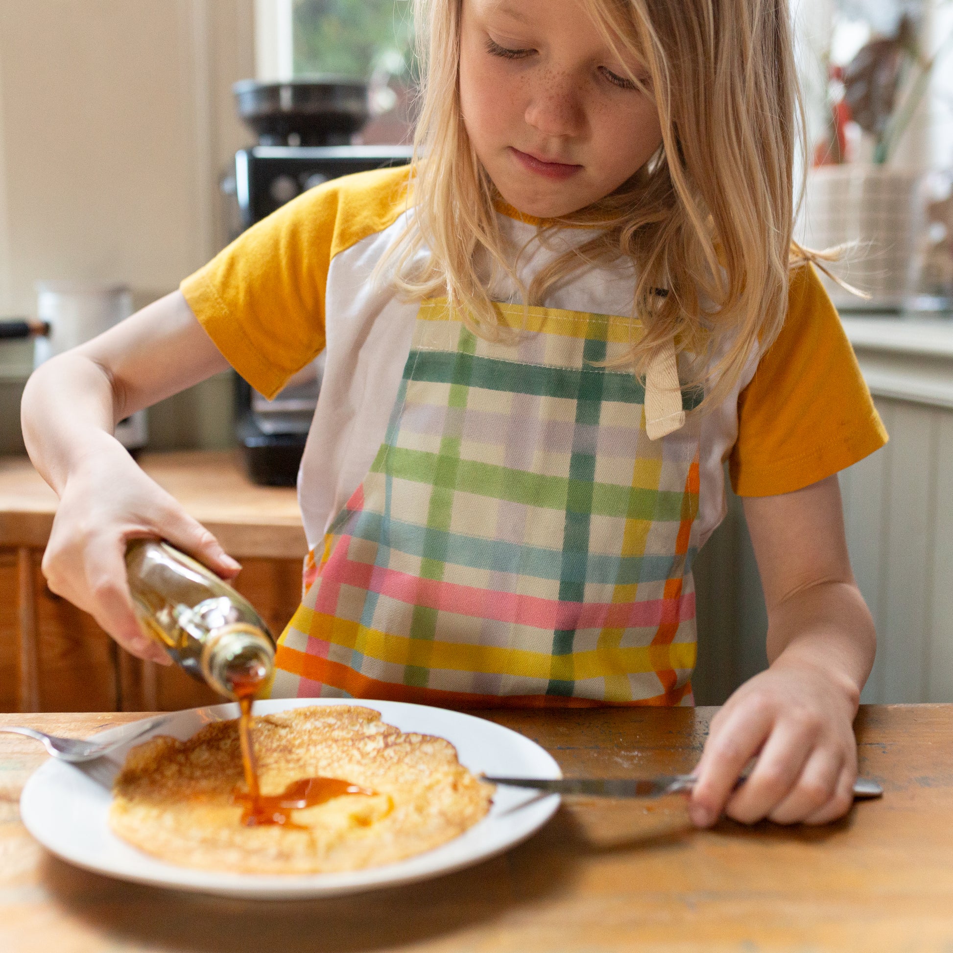Children's apron with adjustable neck strap. 100% cotton. Colourful gingham design. Made in Britain.