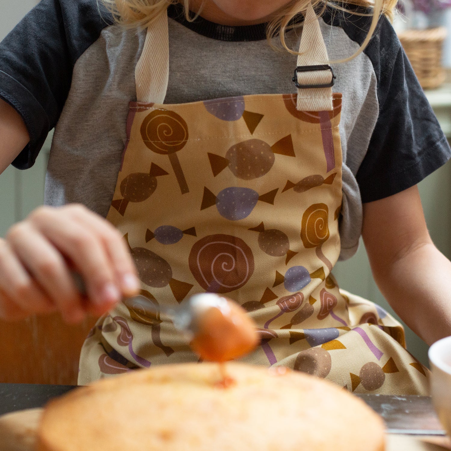 Sweetie design children's apron with adjustable strap, 100% cotton and made in Britain.
