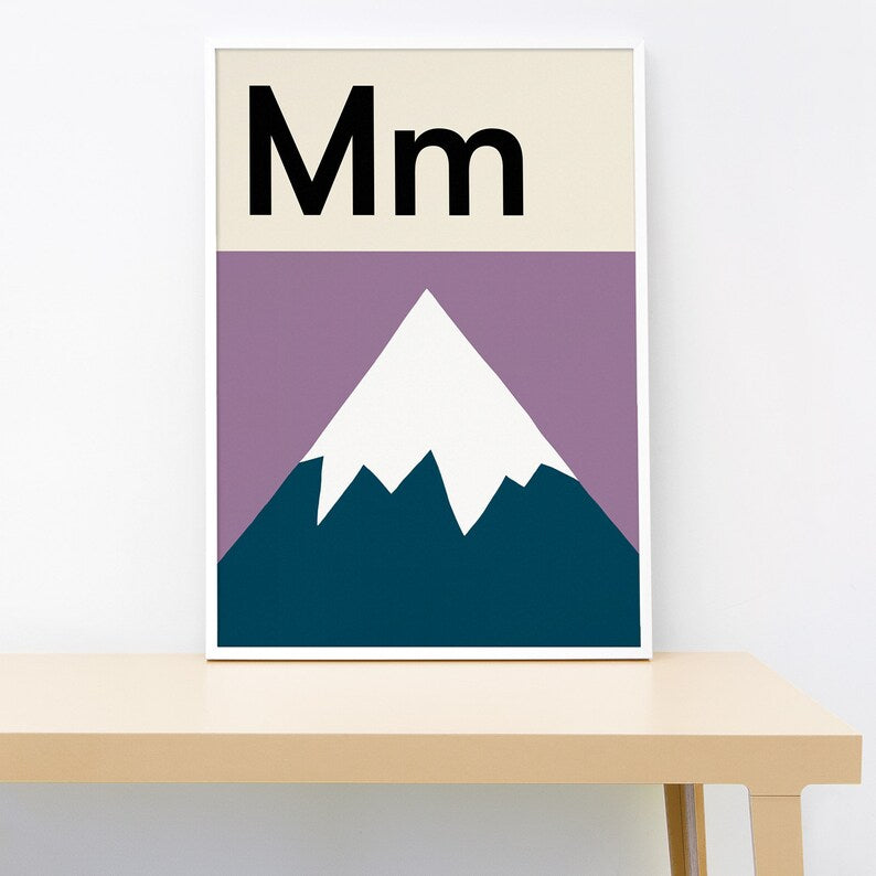 Poster with 'Mm' letter design featuring a mountain on a table against a white wall