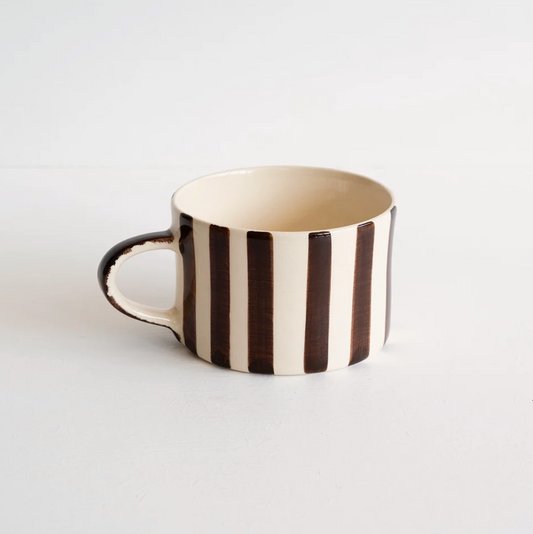 A ceramic coffee mug with vertical dark brown and cream stripes, featuring a dark brown handle, set against a plain white background.