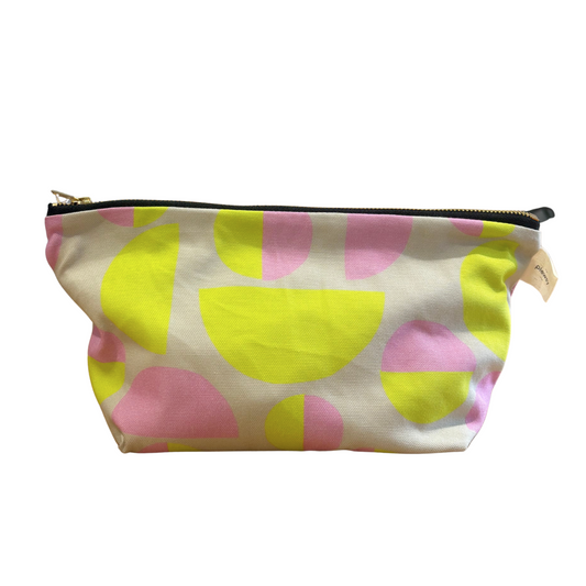 A small zippered pouch with a colorful abstract pattern of pink and yellow semicircles on a white background, shown against a plain white studio backdrop.