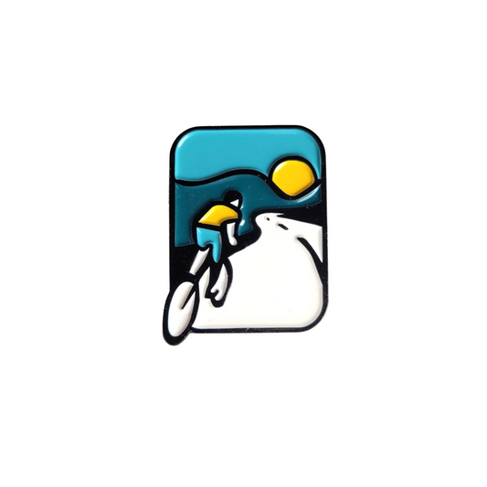 Pin badge with a cyclist on a road against a blue sky with a yellow sun.