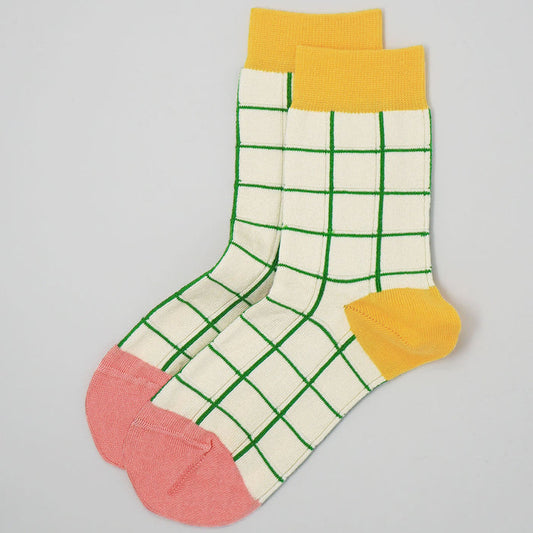 Colorful checkered sock with yellow, green, pink, and white on a gray background