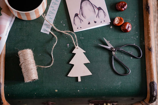 a plywood christmas tree decoration on a chest, surrounded by lots of craft supplies