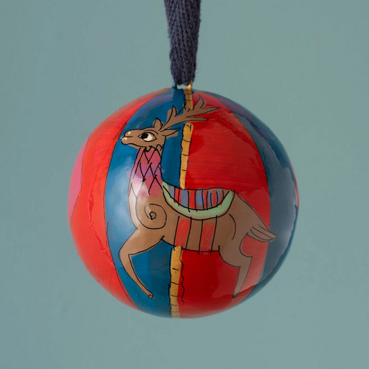 a red and blue bauble with an illustration of a reindeer hung on ribbon