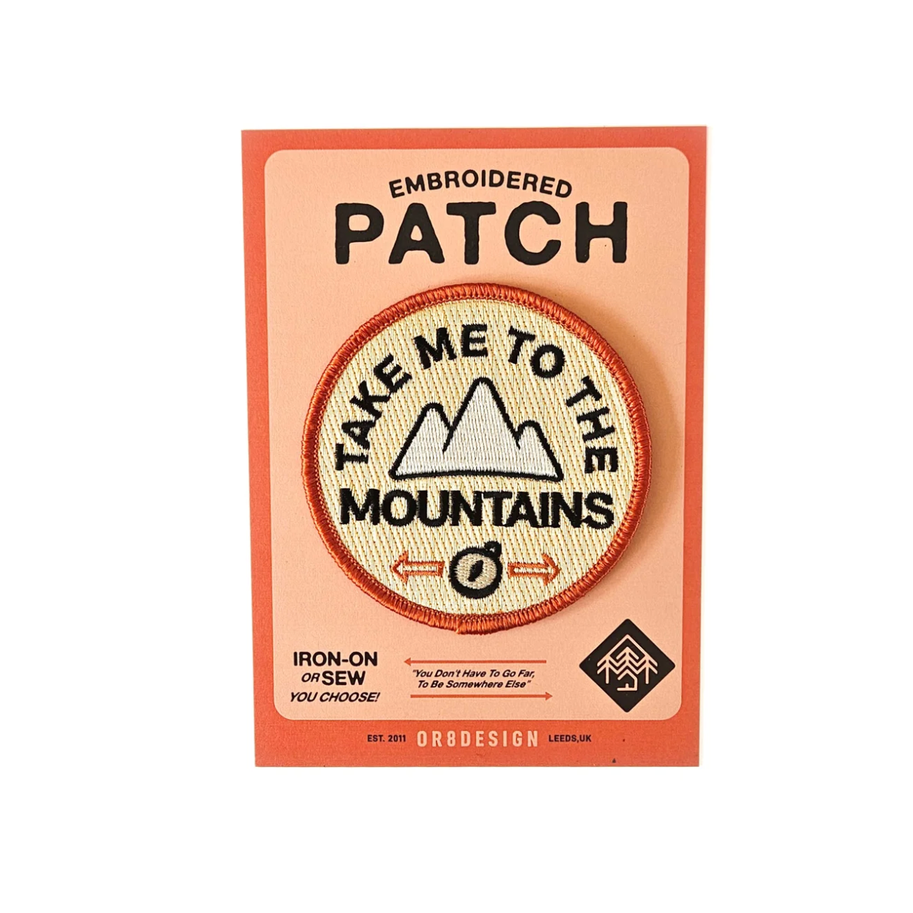 Embroidered patch with 'Take Me to the Mountains' design on a pink card