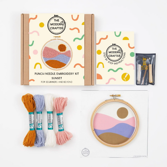 Punch needle embroidery kit with materials and instructions on a white background