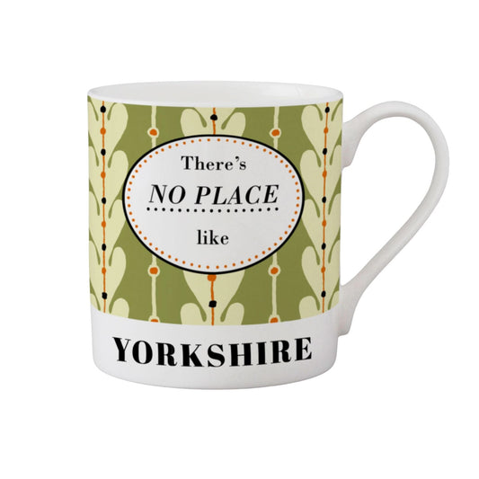 A white ceramic mug featuring a retro-style green and cream patterned wrap with a central white oval that reads 'There's NO PLACE like' and a white lower band with 'YORKSHIRE' in black text.