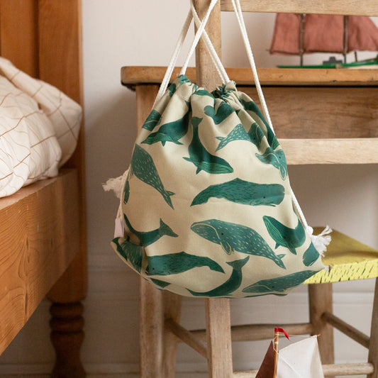 Drawstring bag with blue whale pattern on a wooden stool