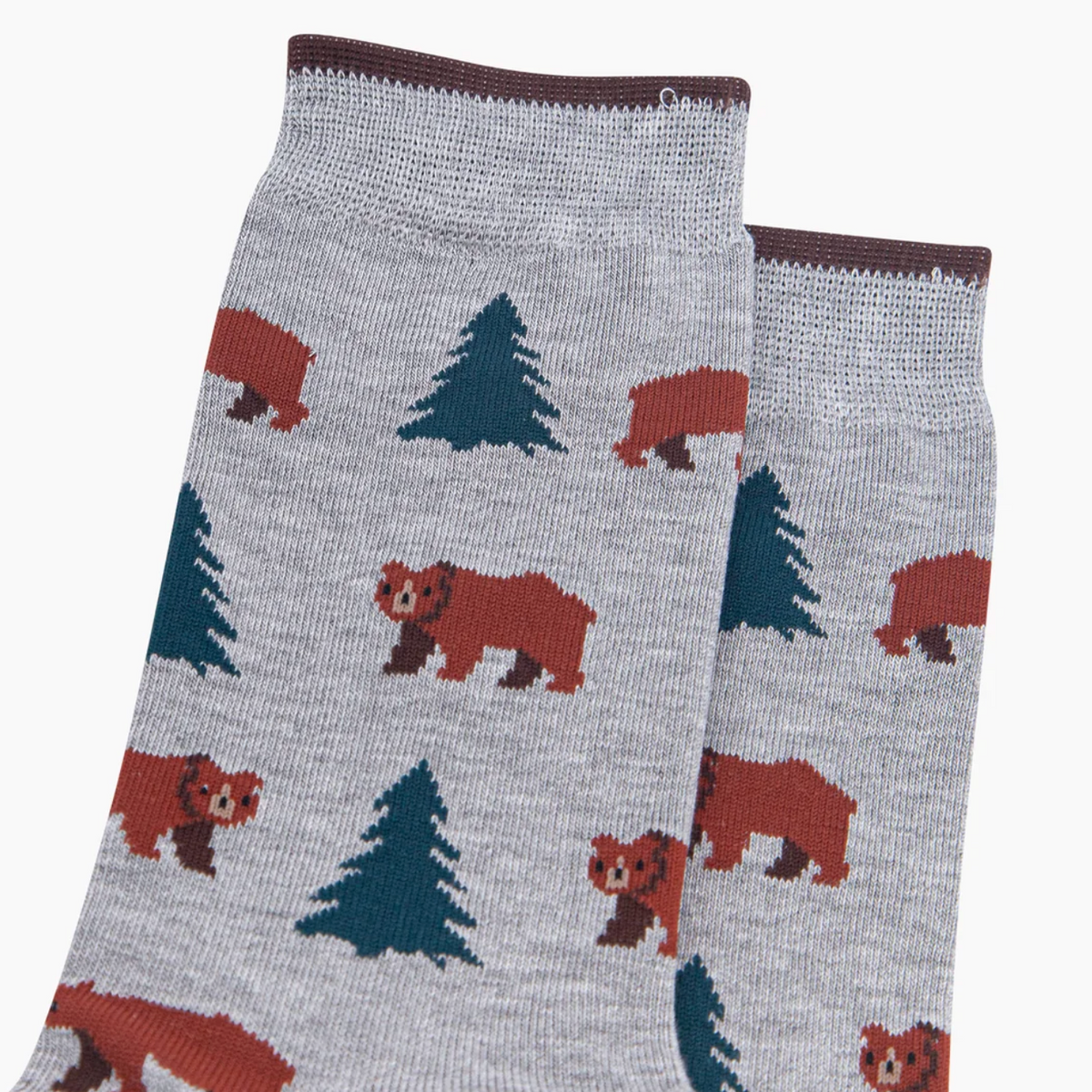 A pair of heather gray crew socks featuring a repeating pattern of brown bears and dark green pine trees, with solid brown ribbed cuffs and toes.